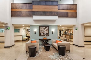 A spacious lobby with two sofas, a coffee table, and a decorative wall piece. - Wingate by Wyndham Chicago Schaumburg (Schaumburg)