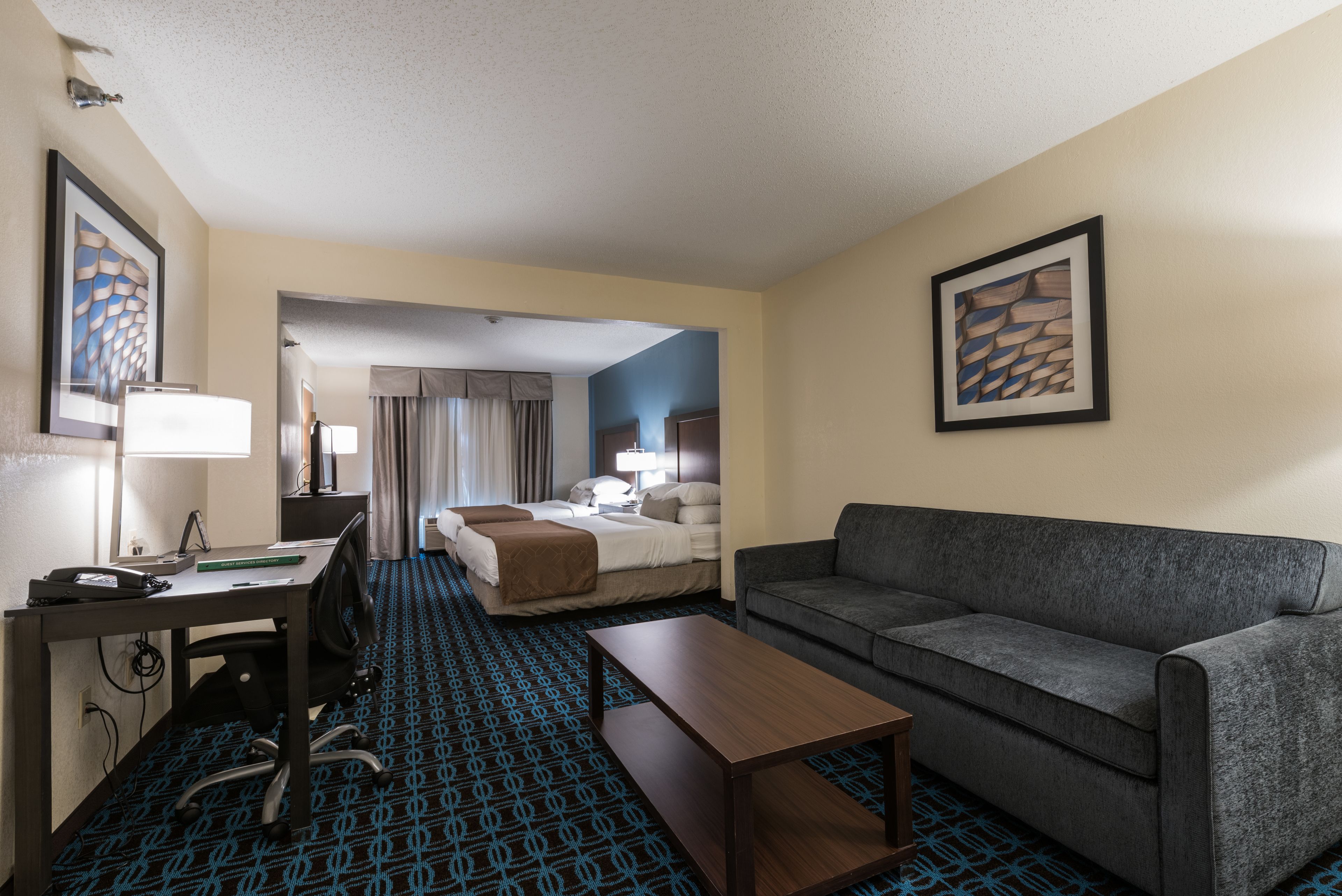 Una habitación de hotel con cama, sofá, escritorio y silla.