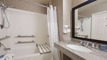 Ein Badezimmer mit Badewanne, Dusche, Waschbecken und Spiegel.