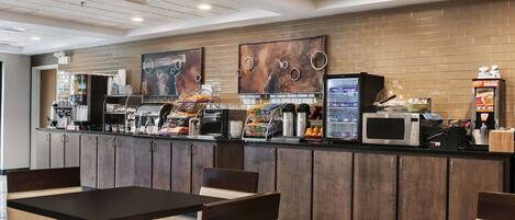 A modern cafe with a brick wall, a counter with coffee machines, and seating areas.