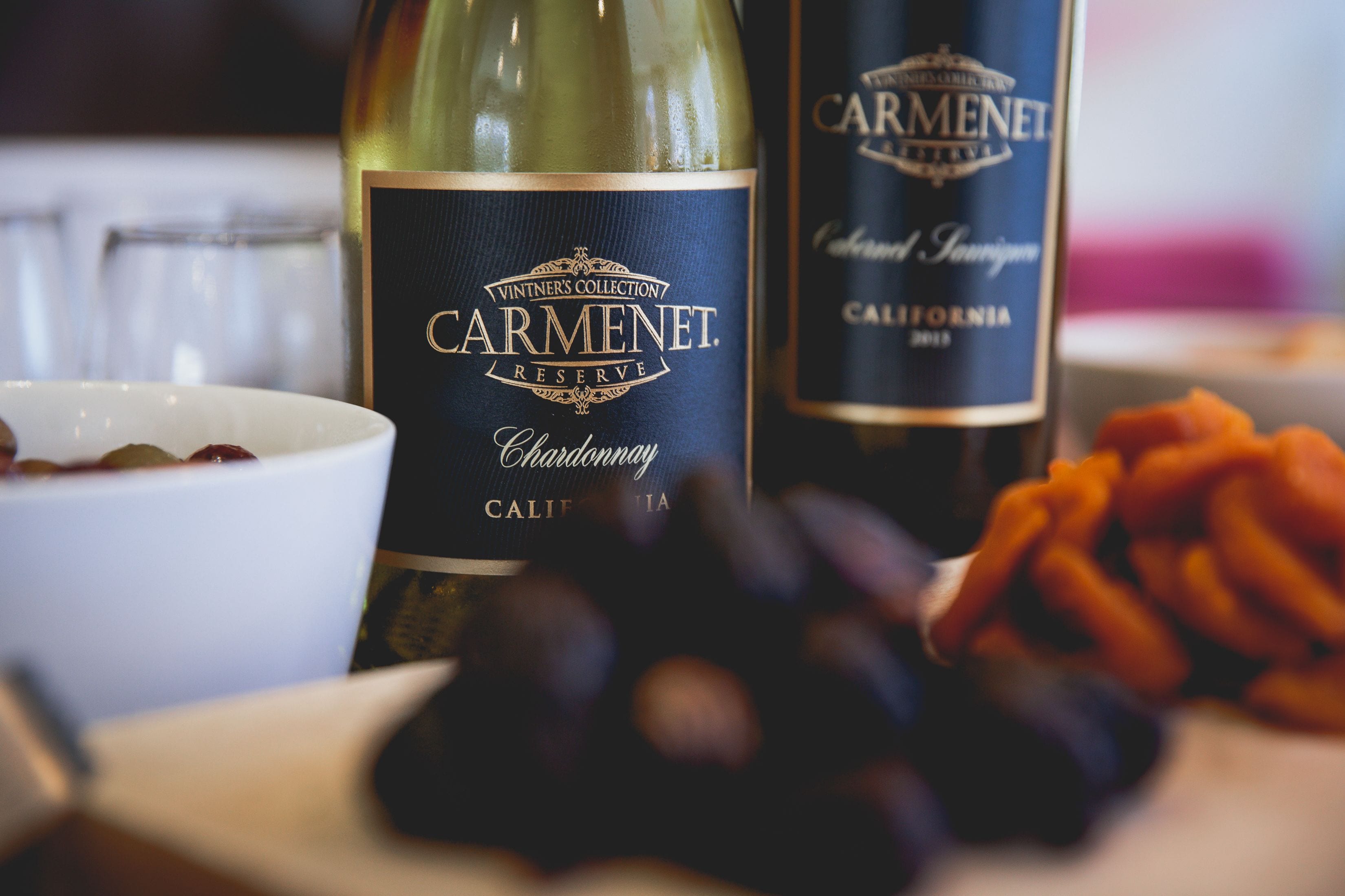 Una botella de Carmenet Reserve Chardonnay y un cuenco de uvas.