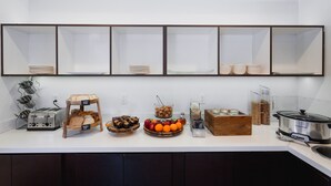 A kitchen counter with various food items, a toaster, a bread rack, a fruit bowl, and a slow cooker. - Menlo Park Inn (Menlo Park)