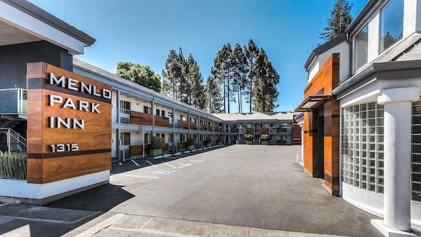 A Menlo Park Inn building with a parking lot and a row of rooms. - Menlo Park Inn (Menlo Park)