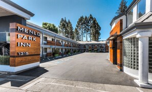 Menlo Park Inn -hotellin rakennus, jossa on parkkipaikka ja rivi huoneita.