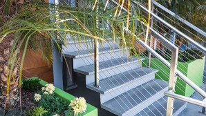 A staircase with metal railings, surrounded by green planters with succulents and flowers. - Menlo Park Inn (Menlo Park)