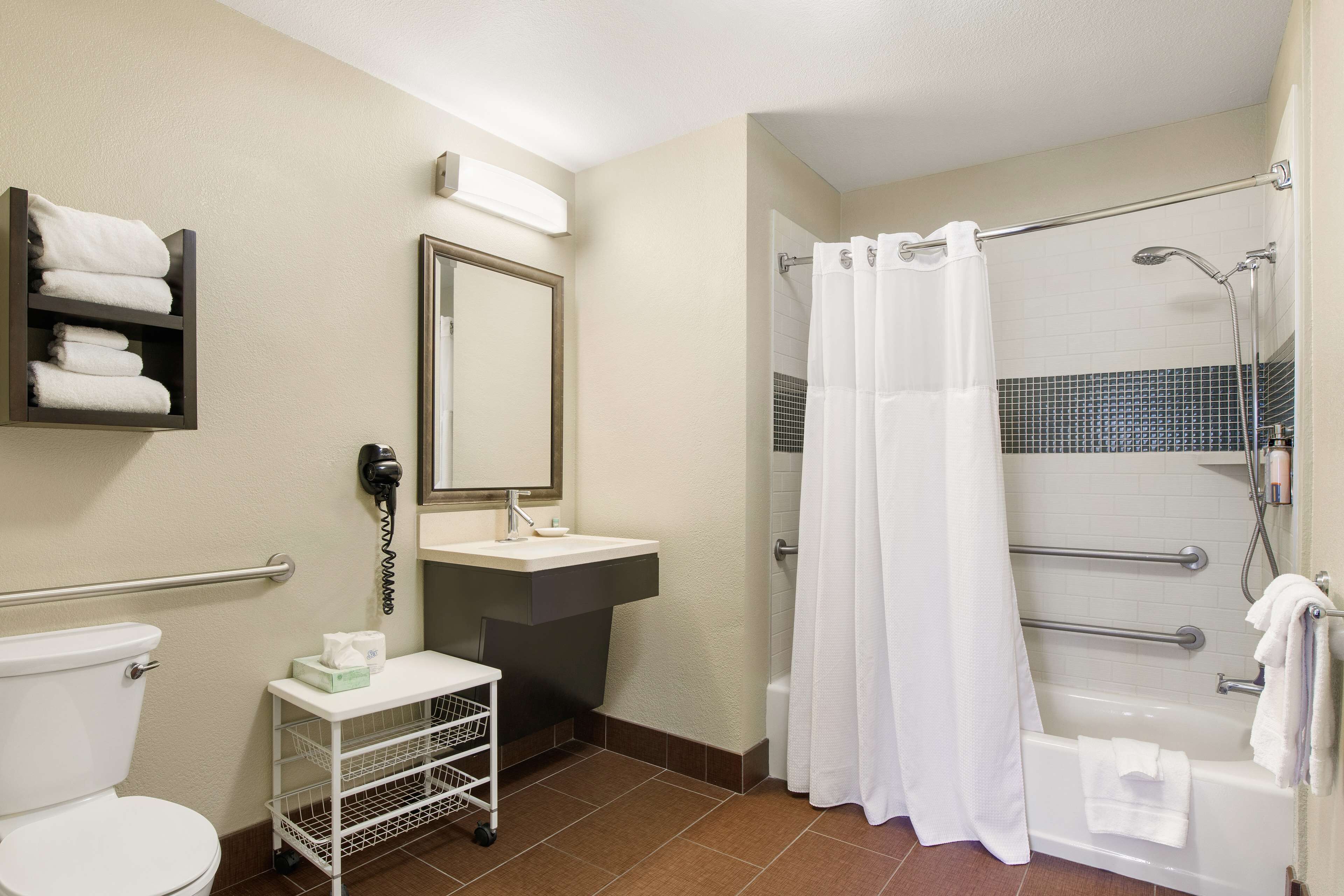 A bathroom with a toilet, sink, and shower area.