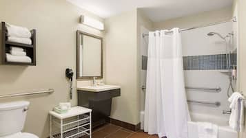 Un baño con inodoro, lavamanos y zona de ducha.
