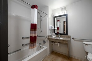 A bathroom with a bathtub, a shower, a sink, and a toilet. - Red Roof Inn & Suites Dover Downtown (Dover)