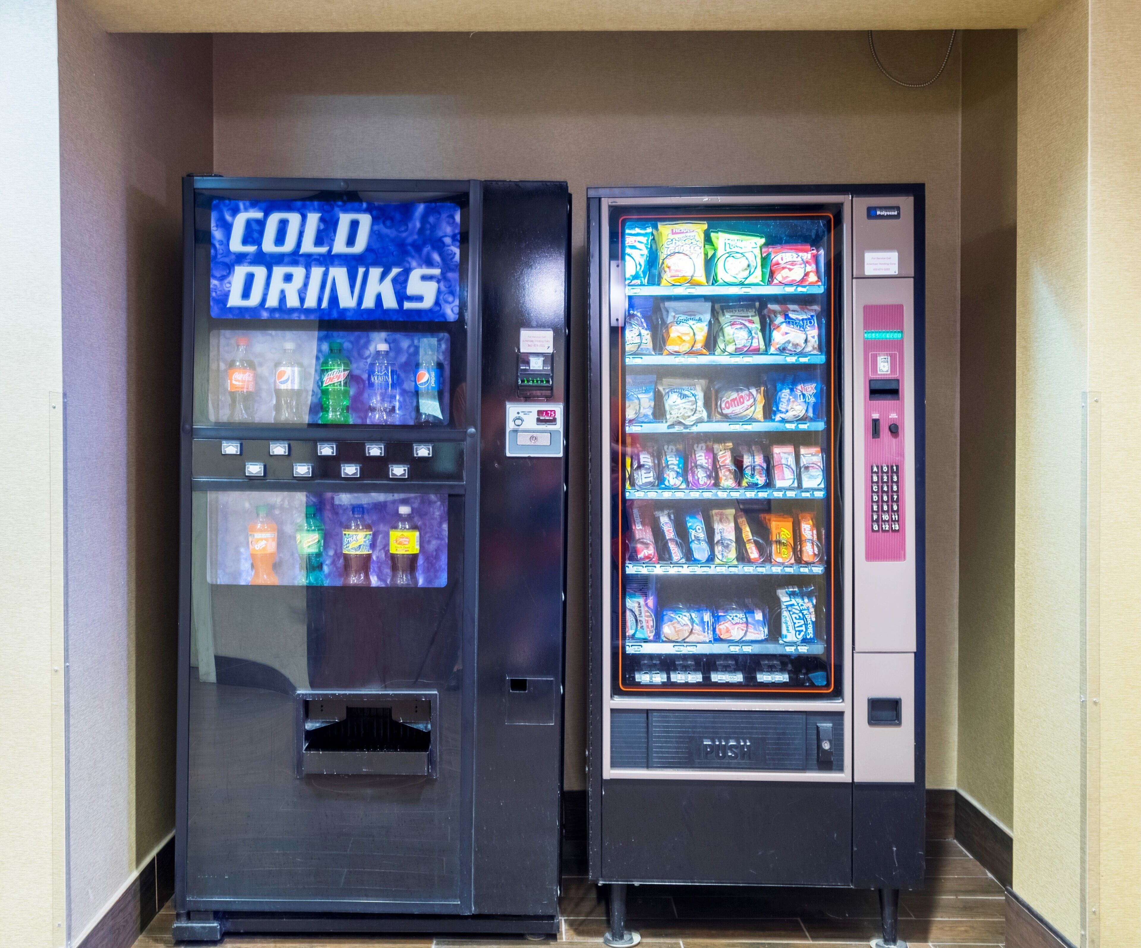 Deux distributeurs automatiques : l’un propose des « BOISSONS FRAÎCHES » et l’autre offre un assortiment de collations et de boissons.