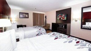 A hotel room with two beds, a desk, a chair, a television, and a mirror. - Red Roof Inn & Suites Dover Downtown (Dover)