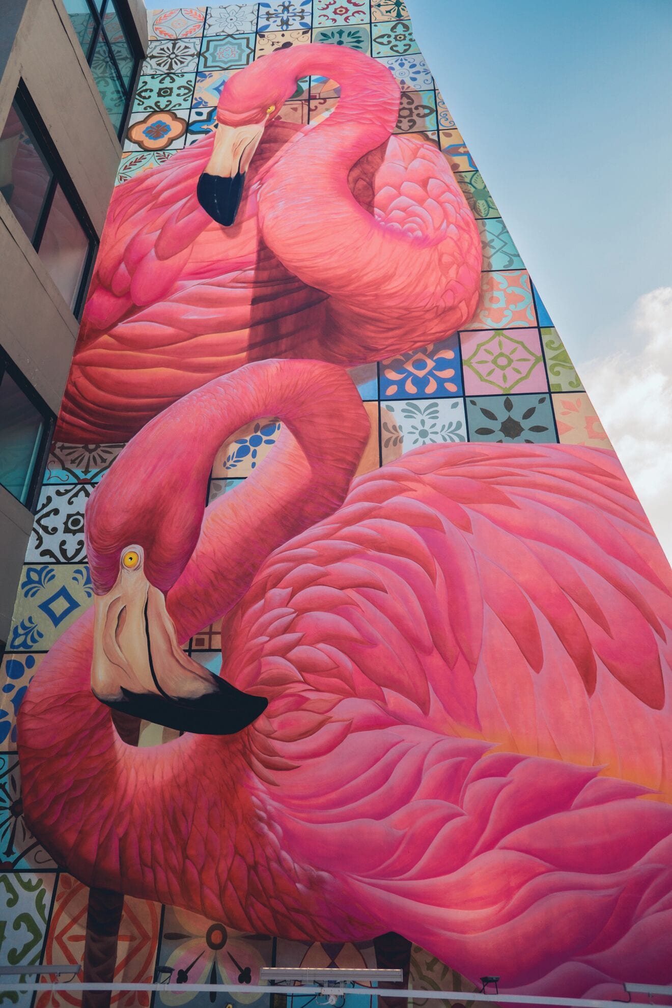 Un gran mural de flamencos rosas en la fachada de un edificio.