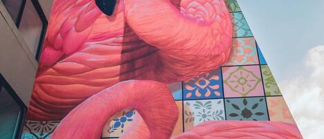 Un gran mural de flamencos rosas en la fachada de un edificio.