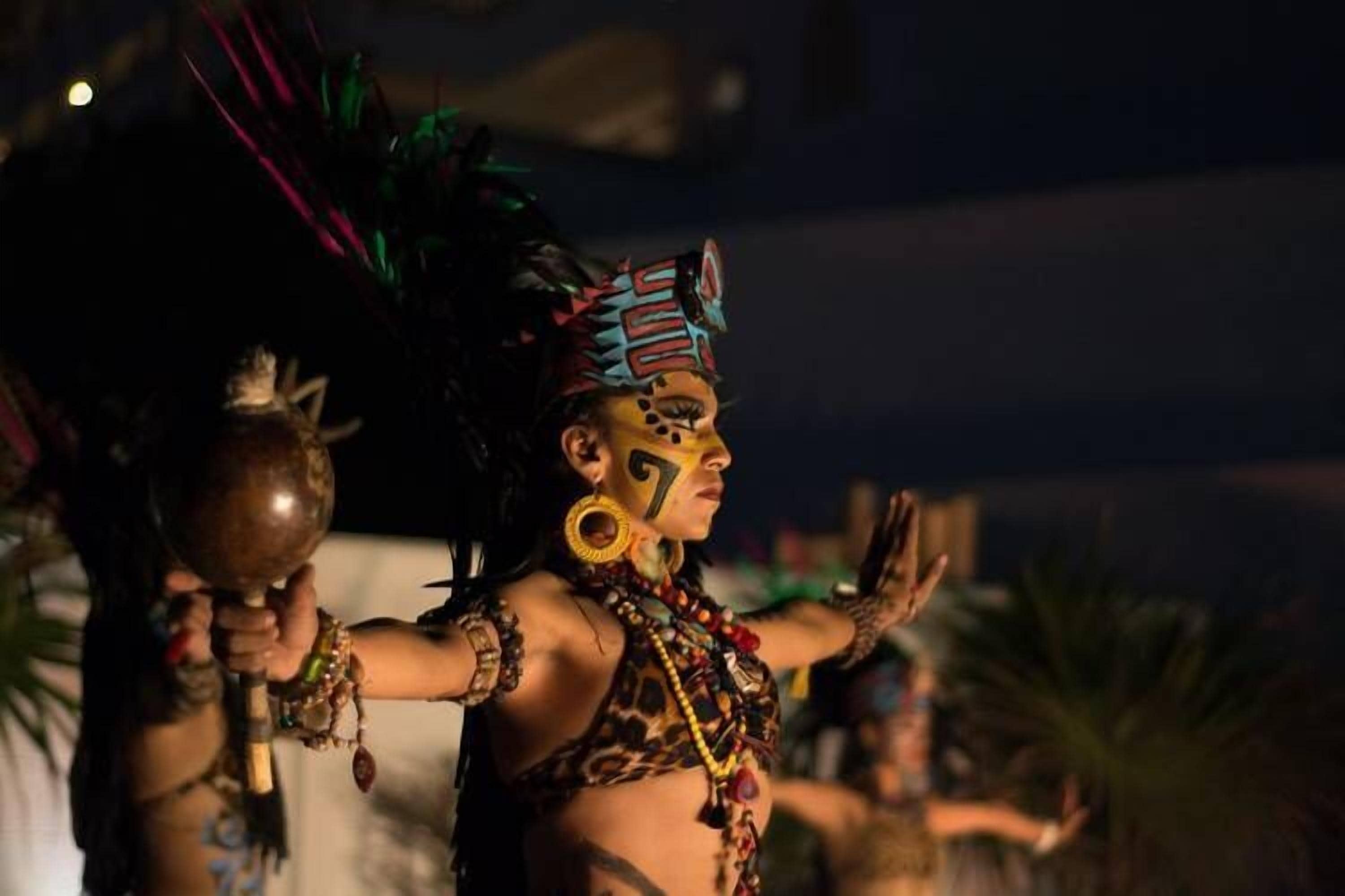 Una persona con vestimenta tradicional, tocado y accesorios.