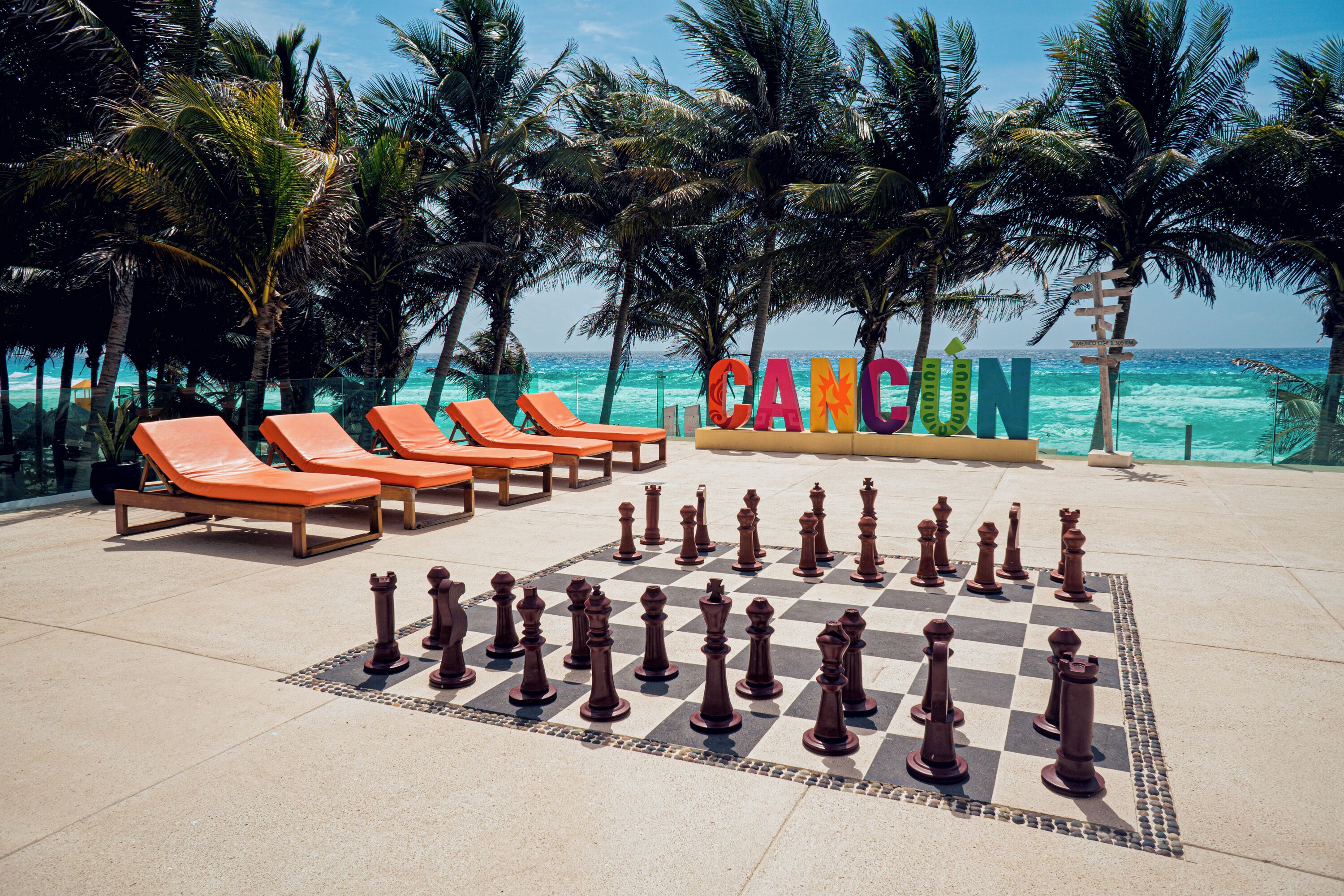 A board game setup on a patio with lounge chairs and palm trees.