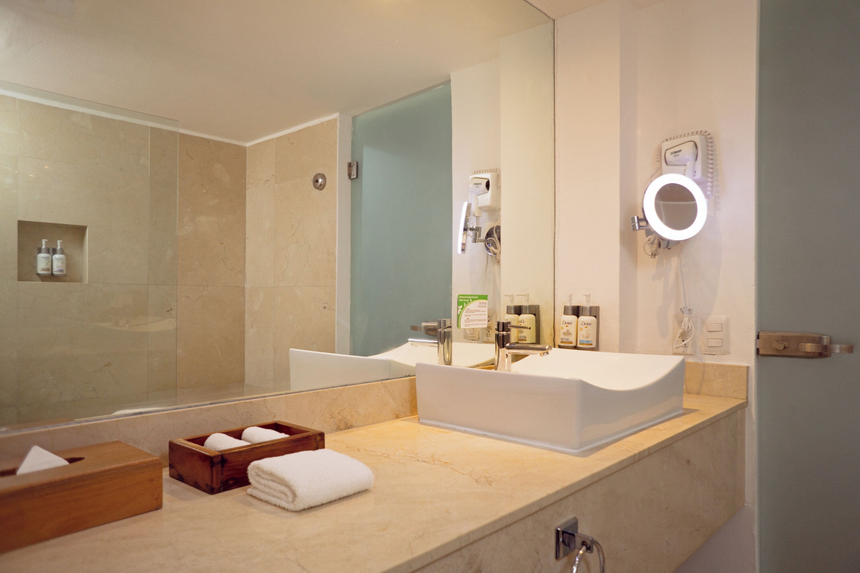 A modern bathroom with a large mirror, a sink, and a shower area.