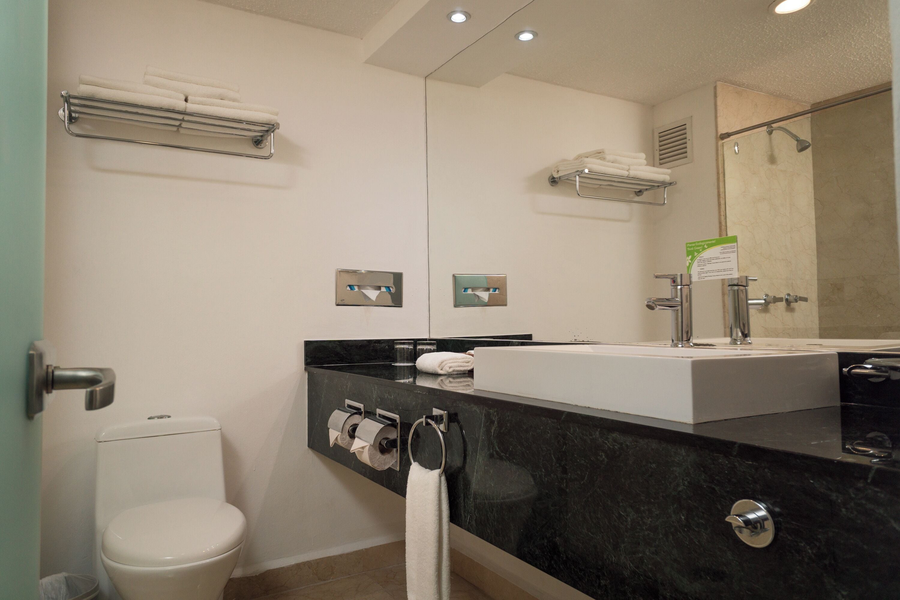 A modern bathroom with a toilet, sink, and shower.