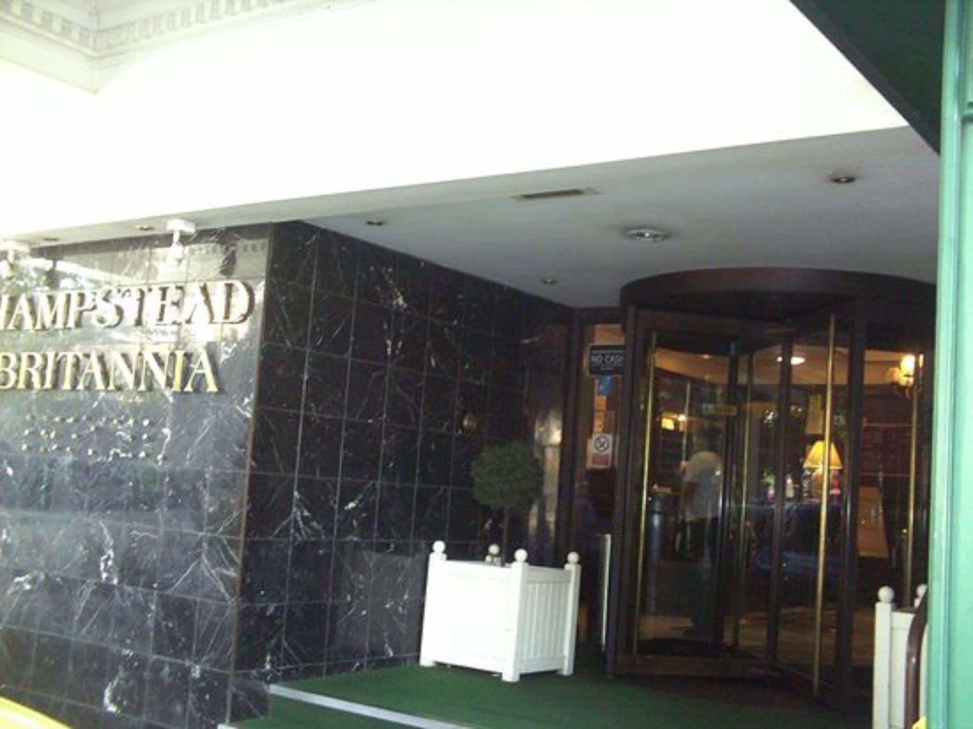 The entrance to Hampstead Britannia with a marble facade and a glass door.