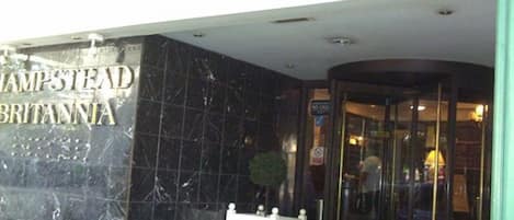 L’entrée de l’hôtel Hampstead Britannia se distingue par sa façade en marbre et sa porte en verre.