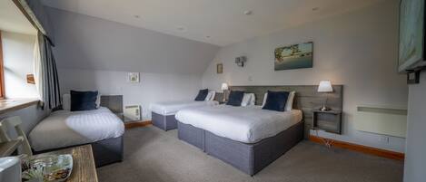 A hotel room with two beds, a desk, and a chair.