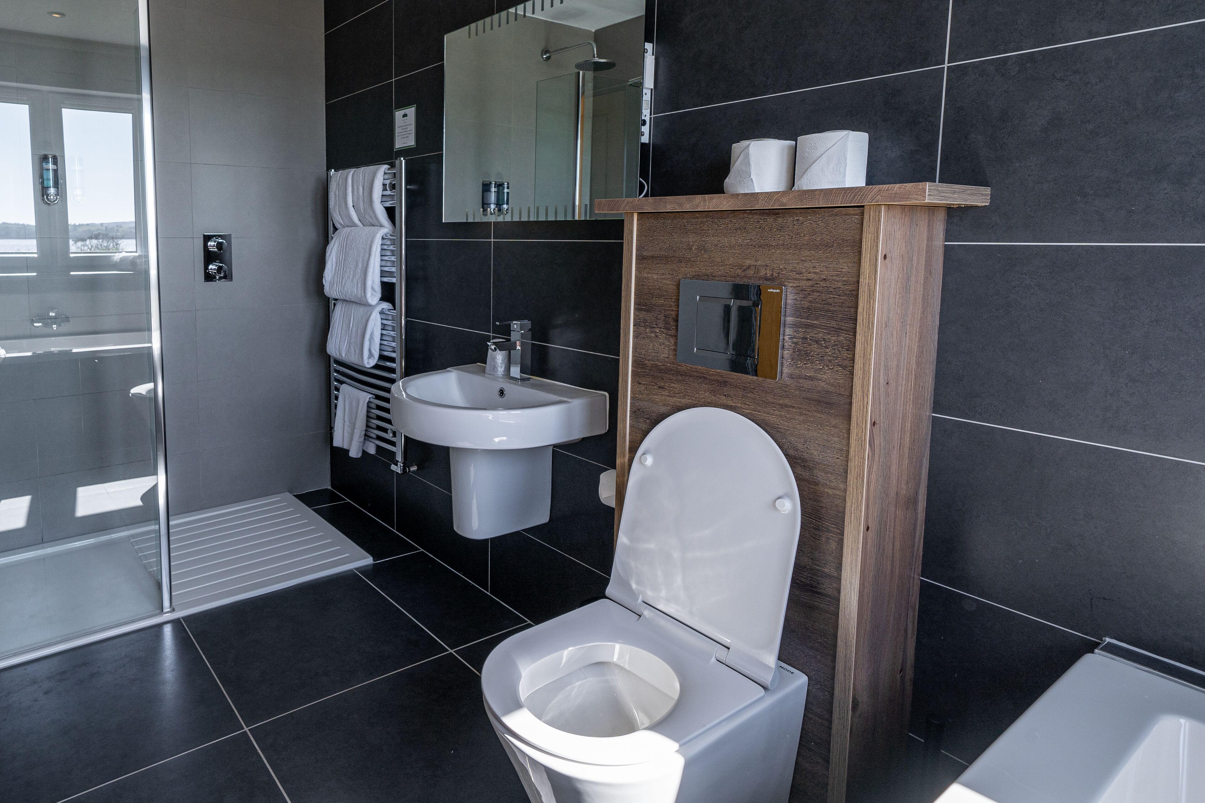 A modern bathroom with a toilet, sink, and shower.