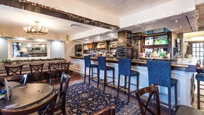 A bar area with a counter, stools, and a patterned carpet. - The Beaufort Hotel (Chepstow)