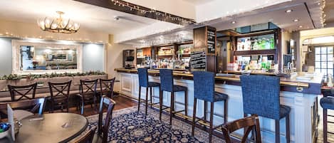 A bar area with a counter, stools, and a patterned carpet.