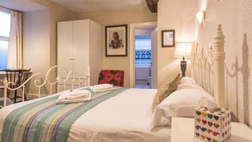 Un dormitorio ordenado con cama, mesita de noche y una silla.