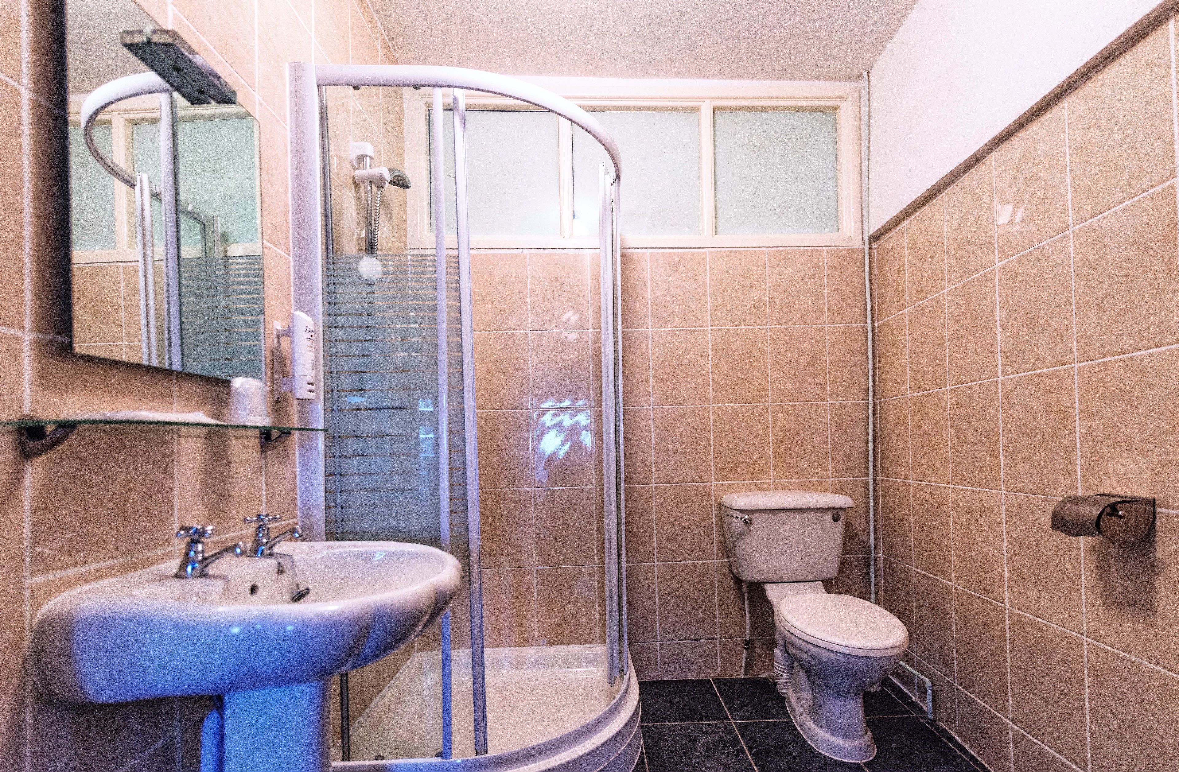 Ein Badezimmer mit Duschkabine, Waschbecken und Toilette.