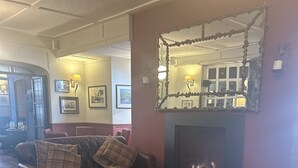 A cozy living room with a leather sofa, a wooden coffee table, and a patterned rug. - The Beaufort Hotel (Chepstow)