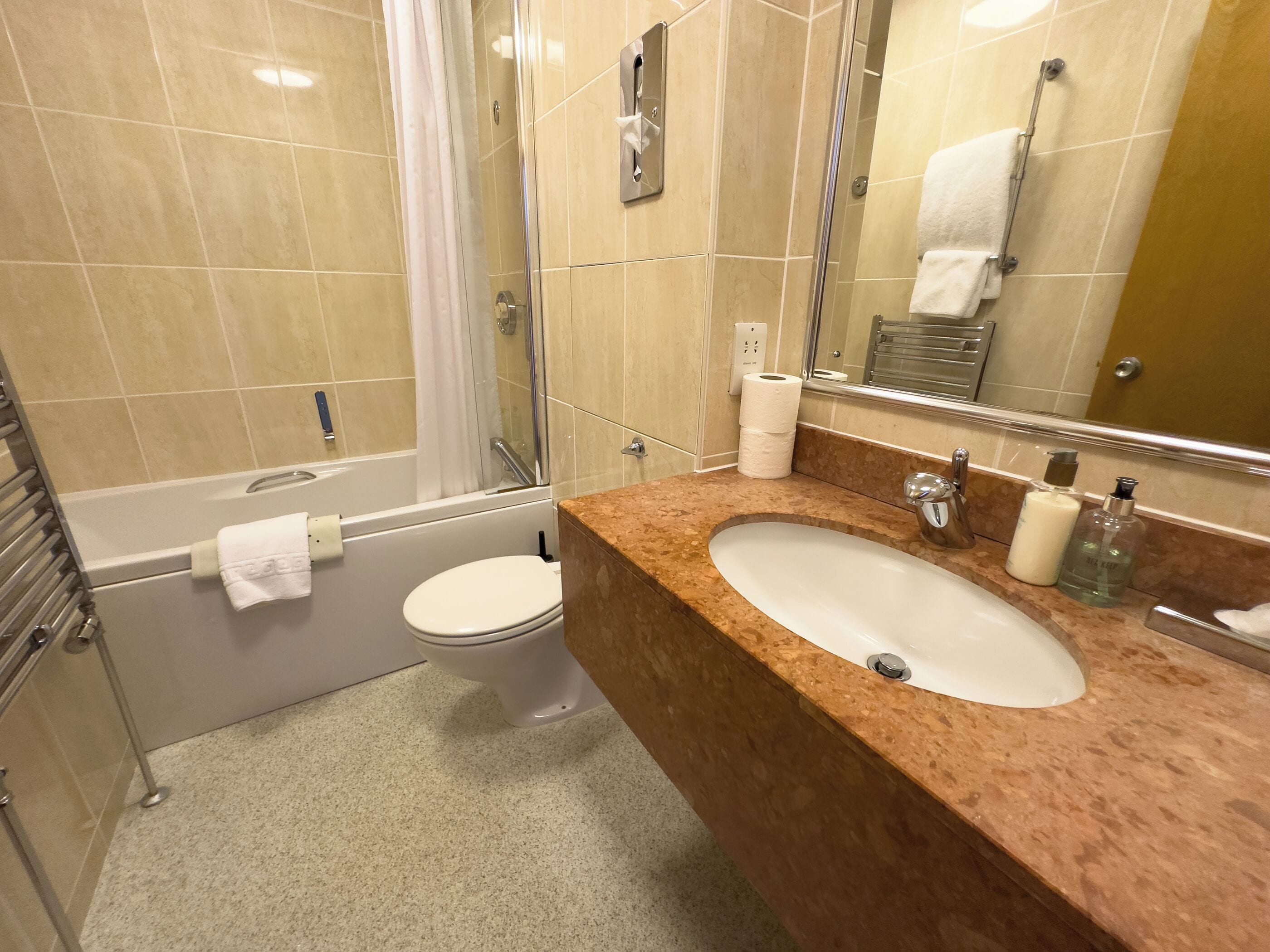 A modern bathroom with a bathtub, toilet, and sink.