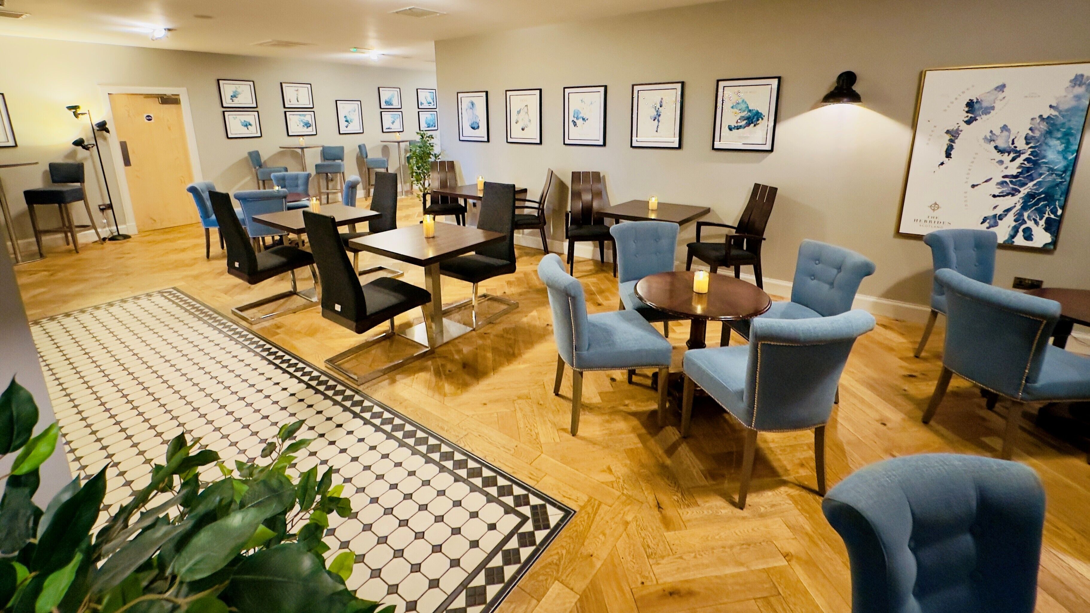 Un comedor con una mezcla de sillas tapizadas en azul y negro, suelo de madera y alfombra estampada.