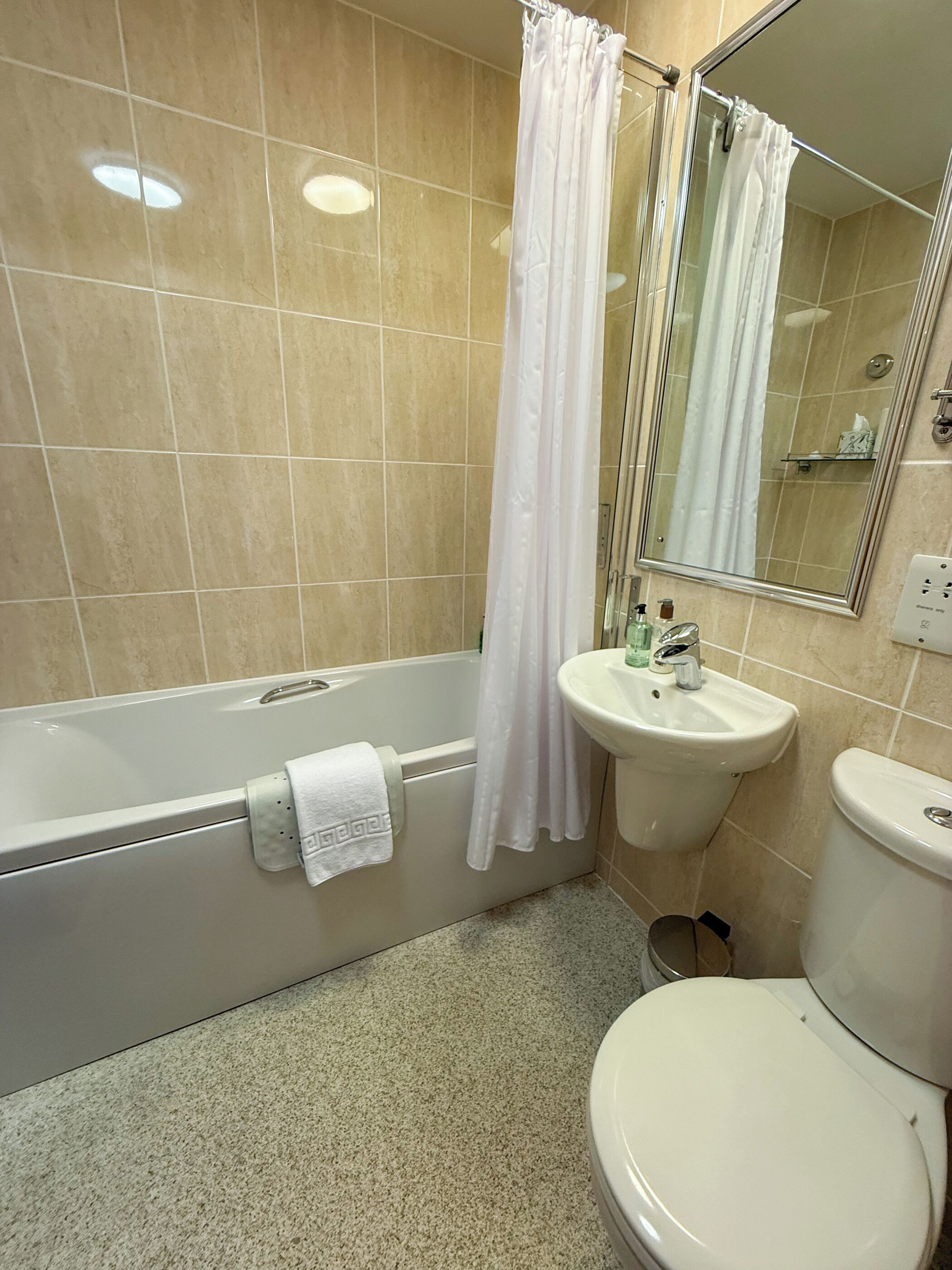 A bathroom with a bathtub, a sink, a toilet, and a shower curtain.