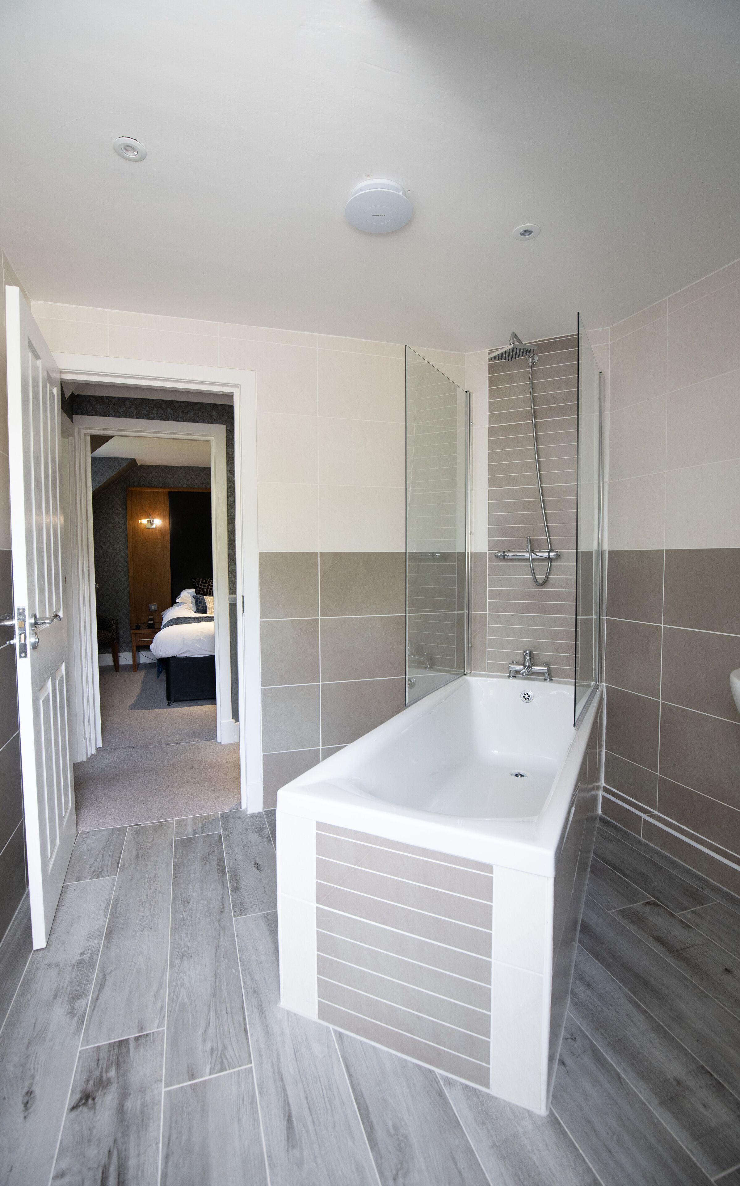 A modern bathroom with a large bathtub, a glass shower enclosure, and a walk-in shower.