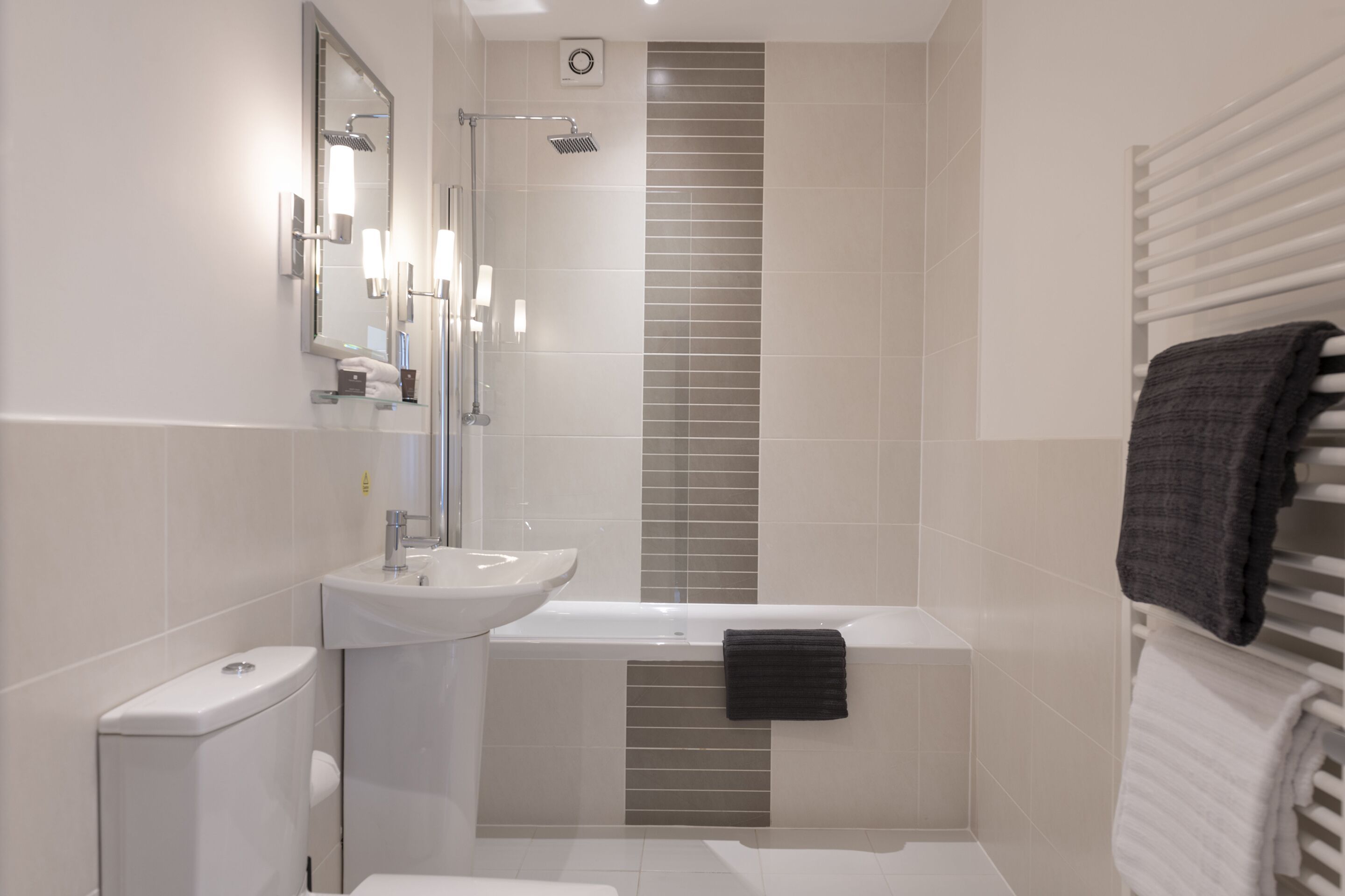 Un baño moderno con lavamanos blanco, bañera y ducha.