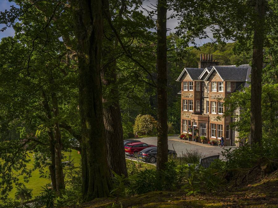 A large, multi-story building surrounded by lush greenery.