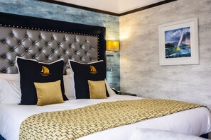 Relax in a cozy retreat with a tufted headboard, throw blanket, and sailboat-themed pillows.