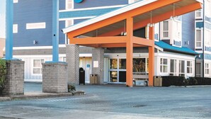 A Best Western hotel with a blue and white exterior, a covered entrance, and a sign indicating it is the Peace Arch Inn.