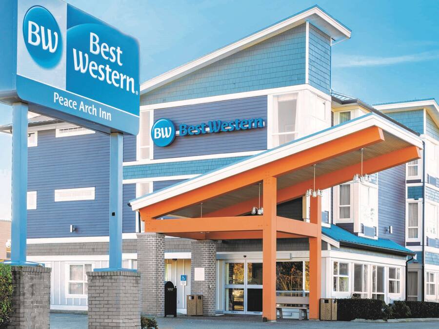 A Best Western hotel with a blue and white exterior, a covered entrance, and a sign indicating it is the Peace Arch Inn.