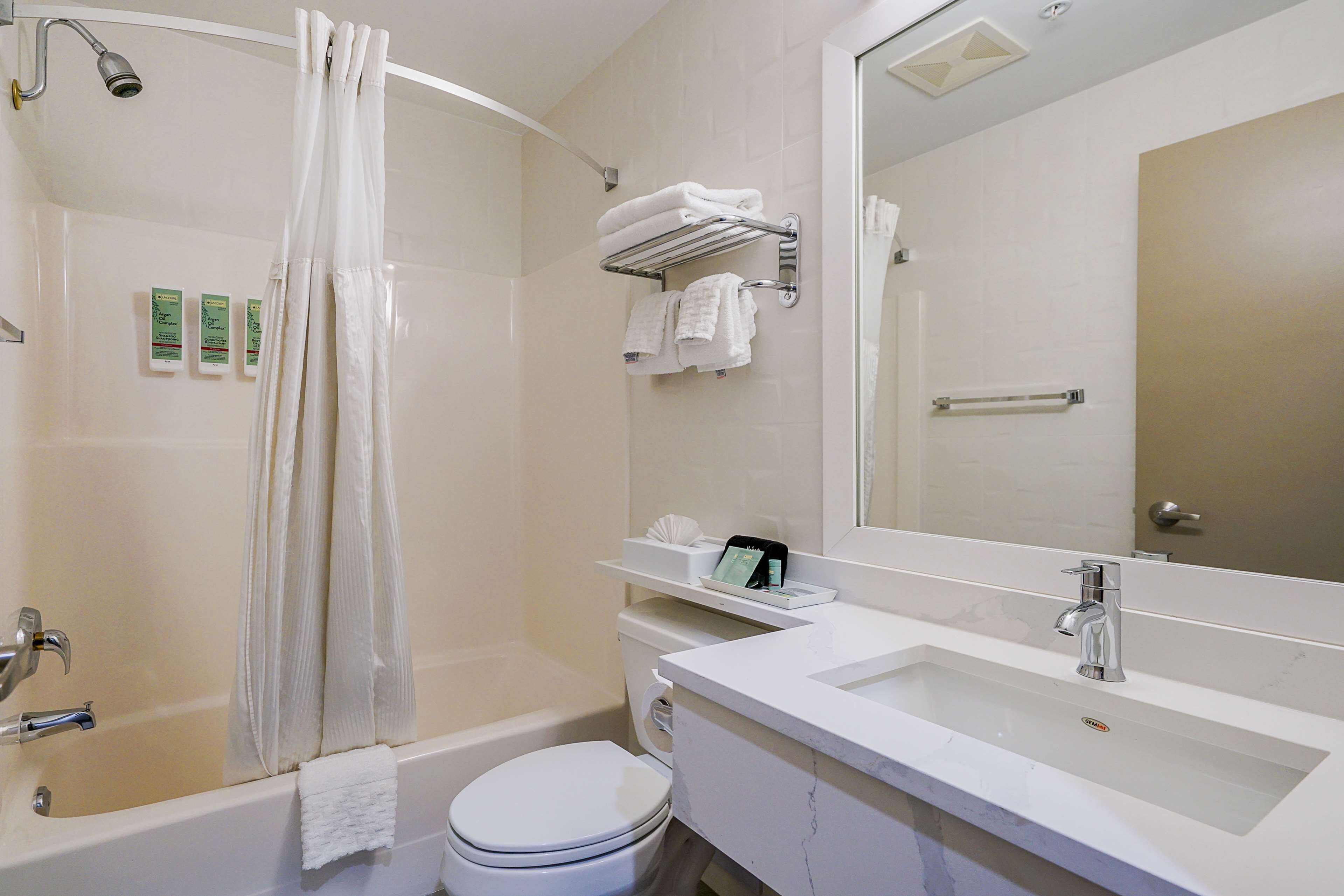 A modern bathroom with a bathtub, toilet, and sink.