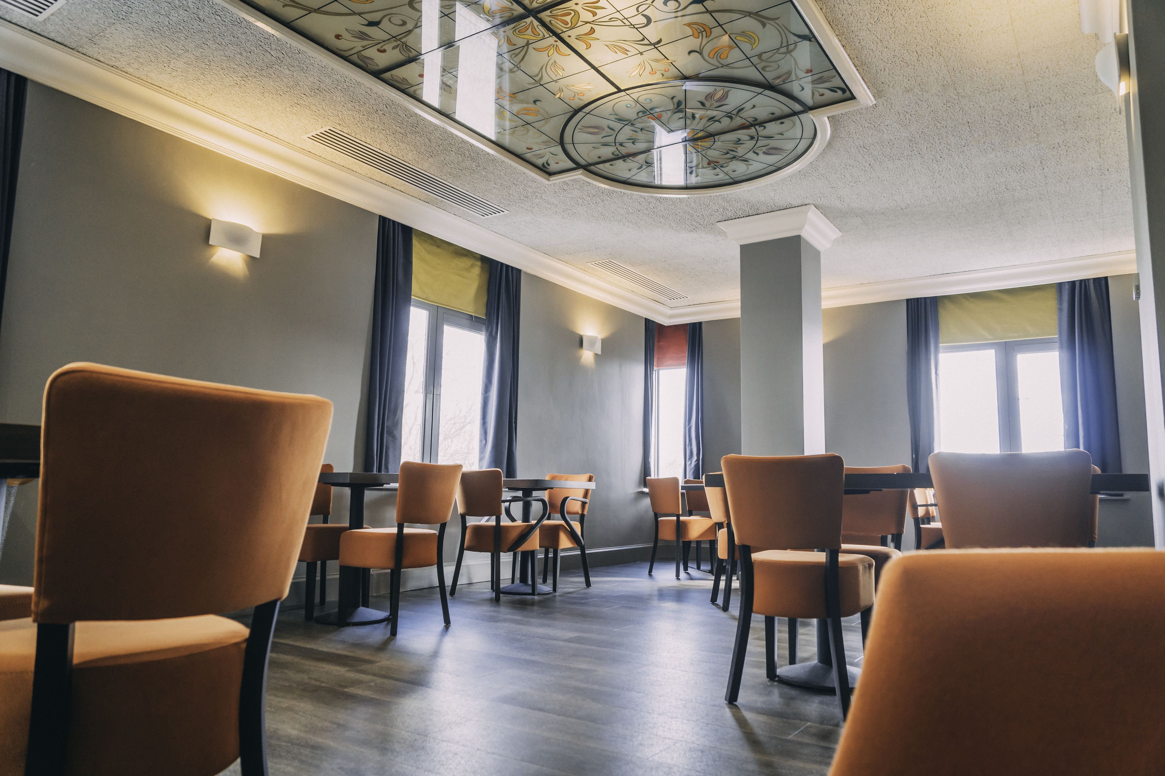 Una sala conferenze con soffitto alto, ampie finestre e arredi moderni.