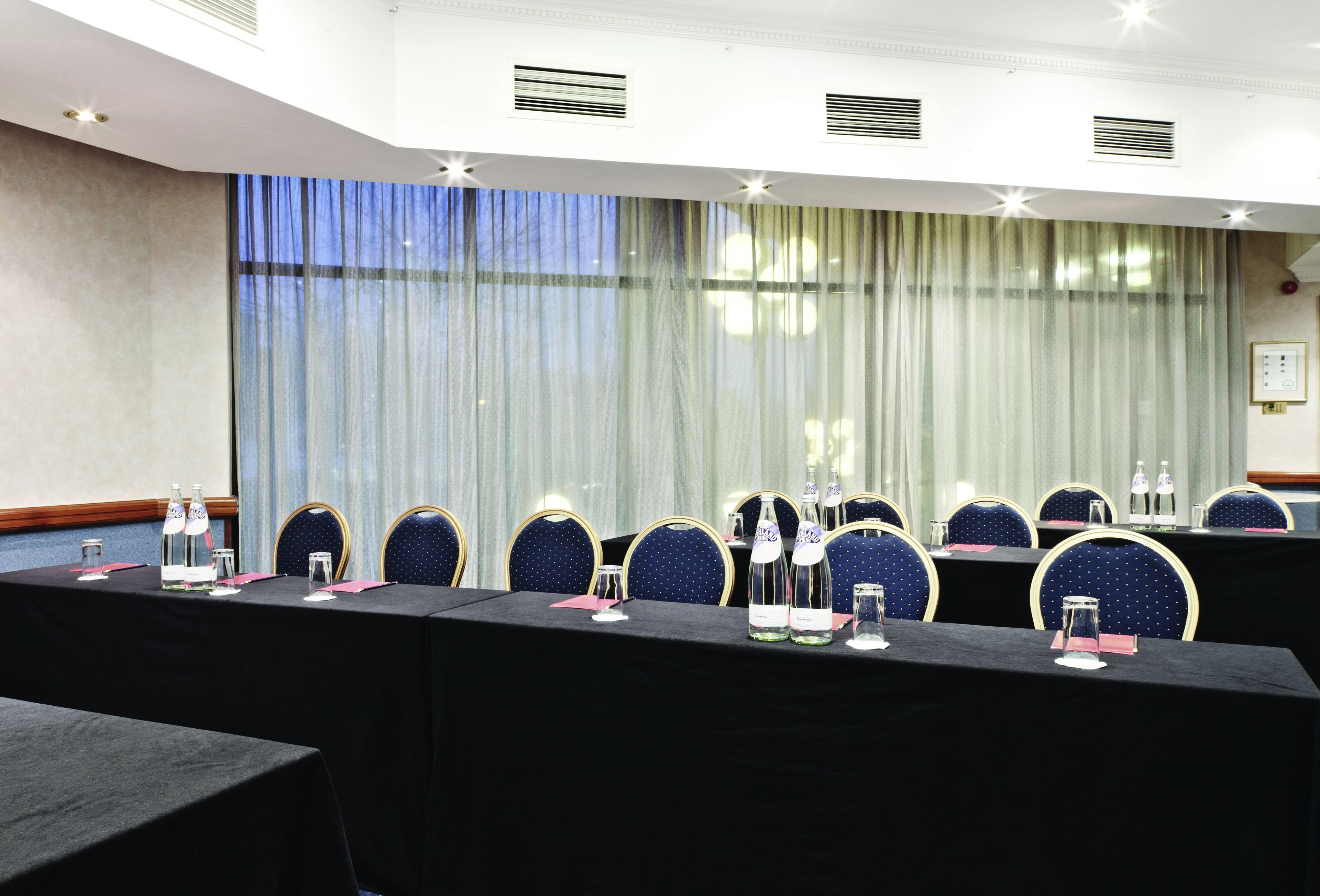 A conference room with a long table, chairs, and water bottles.
