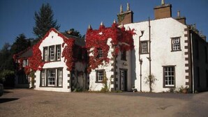 A two-story building with a white facade and red ivy. - Clanabogan Country House B&B (Omagh)