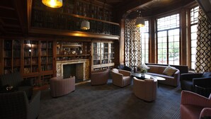 A library with bookshelves, a fireplace, and seating areas. - B+B Edinburgh (Edinburgh)