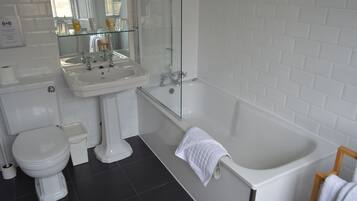 A bathroom with a white toilet, a sink, and a bathtub.
