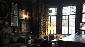 A cozy lounge area with a sofa, armchairs, and a coffee table. There are framed pictures on the wall and a lamp on a side table. - B+B Edinburgh (Edinburgh)