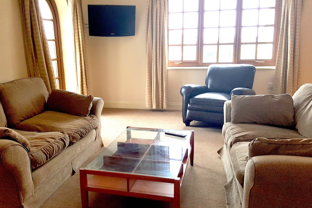 A living room with a sofa, armchair, and a coffee table.