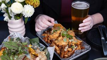 A dining table with a meal consisting of fries, a salad, and a drink.