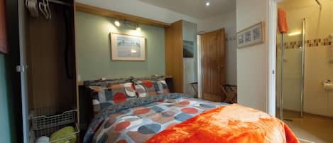Une chambre à coucher avec un lit, une armoire, une douche et un tableau encadré au mur.