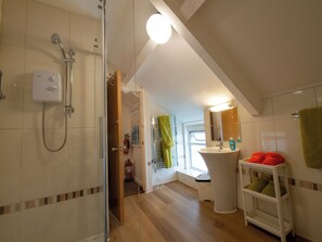 Un baño con ducha, lavabo e inodoro.