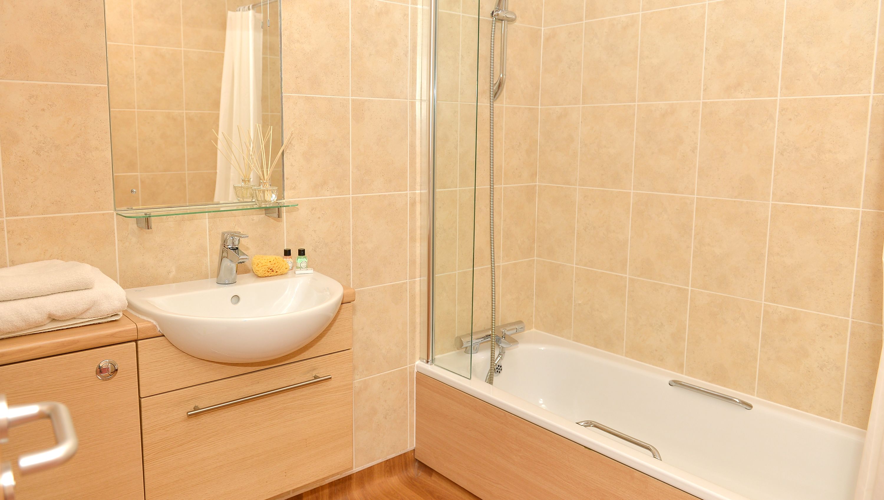Un bagno con lavandino bianco, box doccia in vetro e vasca da bagno.